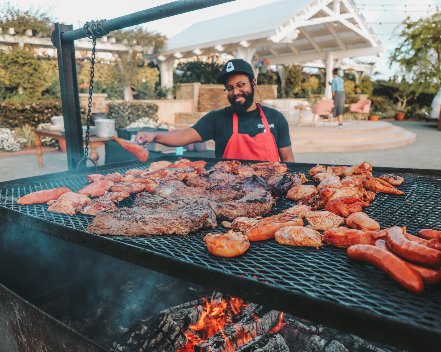 A man flips the chicken while all the tri tip, sausage, and ribs continue to cook during an on-site catering event with Corbin's Q in San Diego. 