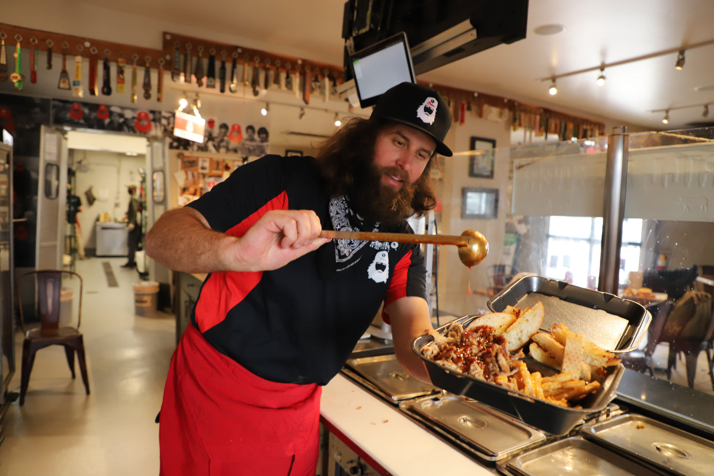 Corbin adding BBQ sauce to a pulled pork plate from Corbin's Q in the college area