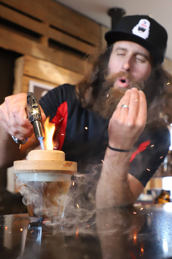 Bartender torching a smokey old fashioned from Corbin's Q bar in San Diego. 